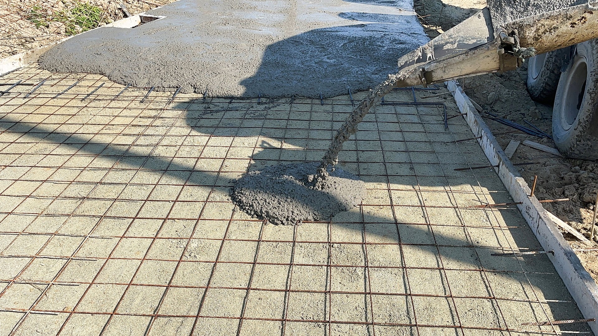 Pouring concrete on reinforced concrete roads using a ready-mix cement truck.